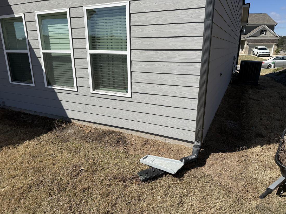 House corner with clean downspout by Kaus Cuts